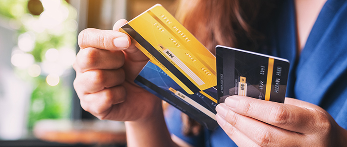 Close up of woman's hand choosing one payment card from among two others.