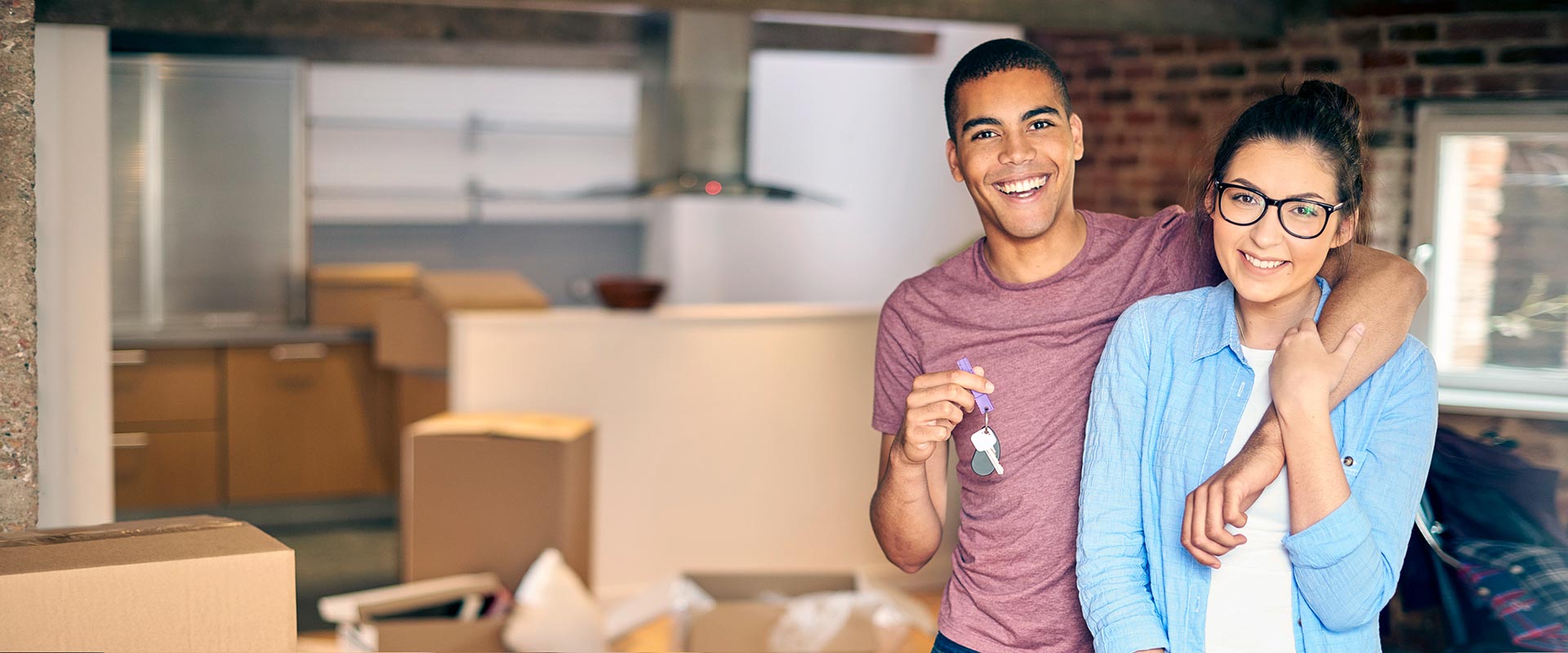 A young couple holding the keys to their first home